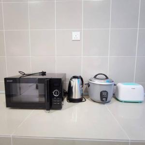 eine Küchentheke mit einer Mikrowelle und einem Toaster in der Unterkunft W39WarmStay@GoldenHills/NightMarket/4R/BBQ in Brinchang