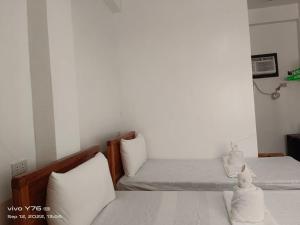 a bedroom with two beds with white pillows at RSK Beach and Accommodation in Dapa