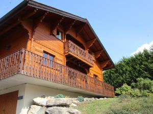 a large wooden house with a balcony on a hill at Chalet 5 chambres pour 10 pers, proche ski bus, terrasse, buanderie, tout confort - FR-1-572-27 in Arâches-la-Frasse