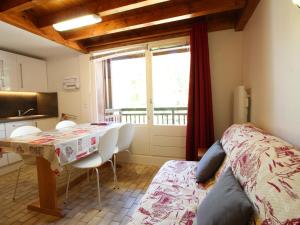 a bedroom with a table and chairs and a kitchen at Studio Les Carroz d'Arâches, 1 pièce, 4 personnes - FR-1-572-60 in Arâches-la-Frasse