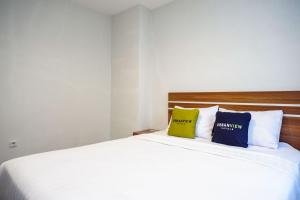 a bedroom with a bed with two pillows on it at Urbanview Hotel Nostos Wonosobo by RedDoorz in Ngasinan
