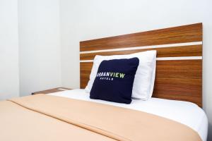 - un lit avec un oreiller bleu dans l'établissement Urbanview Hotel Nostos Wonosobo by RedDoorz, à Ngasinan