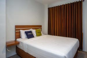 - une chambre avec un grand lit blanc et 2 oreillers dans l'établissement Urbanview Hotel Nostos Wonosobo by RedDoorz, à Ngasinan