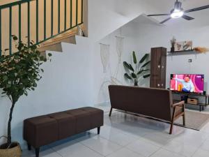 uma sala de estar com um sofá e uma televisão em Private Water Park at Cozy House HS Sweet Homestay em Cukai