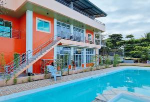 a house with a swimming pool in front of it at RedDoorz Plus @ Galucksea Beach Resort in Caore