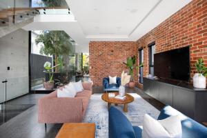 a living room with couches and a brick wall at The Arc Bondi Beach in Sydney