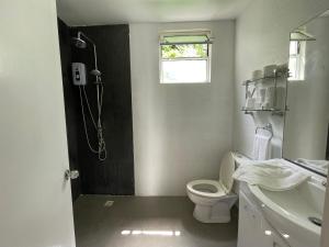 a bathroom with a shower and a toilet and a sink at Everrich Boutique Resort Boracay in Boracay