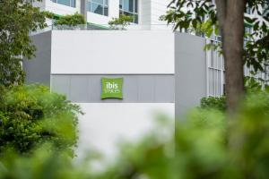a large white building with a sign that reads big smiles at ibis Styles Singapore Albert in Singapore