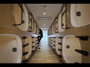 a man standing in the aisle of an airplane at 9h nine hours Ningyocho in Tokyo