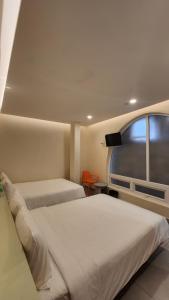 a bedroom with two beds and a window at Raon THT Hotel in Da Lat