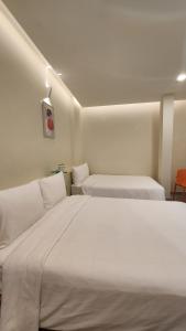 a bedroom with two beds with white sheets at Raon THT Hotel in Da Lat