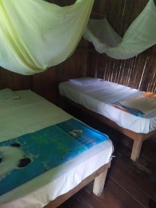 Dos camas en una tienda con un libro. en Shintuya hot springs, en Santa Rosa