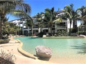 バヤイベにあるBeautiful Apartment in Estrella Dominicus Bayahibeの建物の前に岩を持つスイミングプール