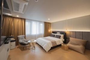 釜山的住宿－동래 덴바스타 호텔，一间卧室配有一张床、一把椅子和电视