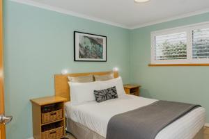 a bedroom with a bed and a window at Albany Harbourside Apartments And Houses in Albany