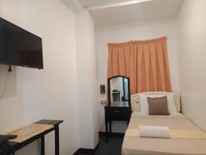 a small bedroom with a bed and a mirror at Amax Inn Cebu in Cebu City
