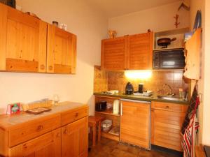 kuchnia z drewnianymi szafkami i zlewem w obiekcie Studio 4 pers au pied des pistes, balcon, casier à skis, TV - FR-1-572-178 w mieście Arâches-la-Frasse