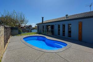 een blauw zwembad voor een huis bij Aqua Tides- Family Home with Pool in Geographe