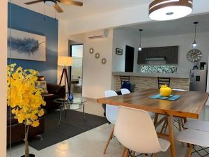 a dining room and living room with a table and chairs at Hermoso apartamento piscina, céntrico, área libre. in Cancún