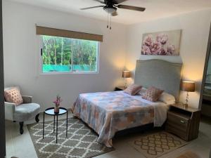 a bedroom with a bed and a chair and a window at Hermoso apartamento piscina, céntrico, área libre. in Cancún +22 photos