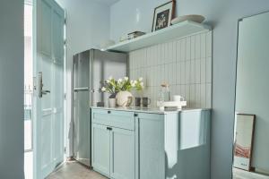 a kitchen with blue cabinets and a blue wall at M Village Tú Xương in Ho Chi Minh City