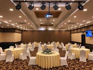 un salón de banquetes con mesas blancas y sillas blancas en U3 HOTEL en Subang Jaya