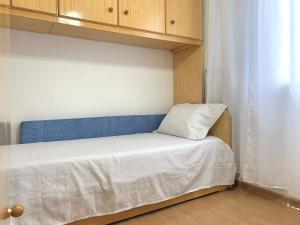 um pequeno quarto com uma cama com uma cabeceira azul em Apartamento próximo do Tiete Plaza Shopping, com vaga e portaria 24h em Osasco
