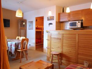 a kitchen and dining room with a table and a microwave at Appartement Les Carroz d'Arâches, 2 pièces, 6 personnes - FR-1-572-97 in Arâches-la-Frasse