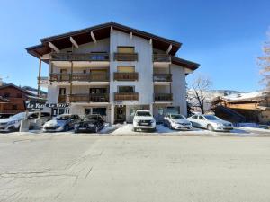 a large building with cars parked in a parking lot at Appartement Les Carroz d'Arâches, 2 pièces, 6 personnes - FR-1-572-97 in Arâches-la-Frasse