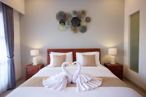 two swans sitting on top of a bed at Kayu Sugih Palace in Sanur