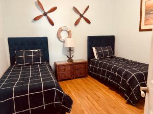 聖彼得海灘的住宿－Two Bedroom Condo With Views Of The Beach & Gulf，一间卧室配有两张床、一张桌子和风扇。