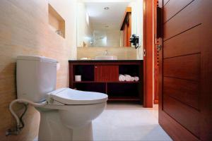 a bathroom with a toilet and a sink at Kayu Sugih Palace in Sanur