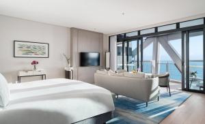a hotel room with a bed and a couch and a television at The Langham, Gold Coast and Jewel Residences in Gold Coast