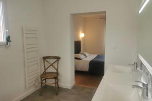 uma casa de banho com uma cama e uma cadeira num quarto em Rhun Izella - Maison avec vue exceptionnelle - Jacuzzi et Sauna face à la mer em Plougasnou
