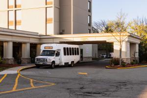 un bus blanc garé devant un bâtiment dans l'établissement Crowne Plaza Newark Airport, an IHG Hotel, à Elizabeth