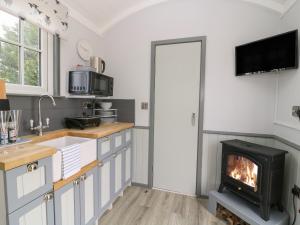 a kitchen with a fireplace and a stove at Bo Peep's Shepherdess Hut in Hull