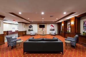 a waiting room with a black couch and chairs at Crowne Plaza Newark Airport by IHG in Elizabeth