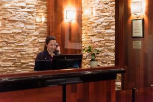 a woman sitting at a table in front of a piano at Crowne Plaza Hotel-Newark Airport, an IHG Hotel in Newark