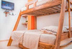 a bedroom with a wooden bunk bed with a television at Mama Lira in Coveñas