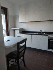 uma cozinha com uma mesa, uma cadeira e um lavatório em Milano Santa Giulia Business Apartment - Olimpiadi 26 em Milão