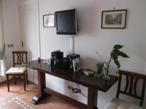 Habitación con mesa de madera y TV en la pared. en B&B Nilo, en Nápoles