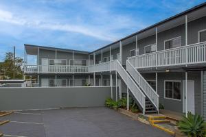 ein Apartmenthaus mit einer Seitentreppe in der Unterkunft Pacific Motel 08 in Forster