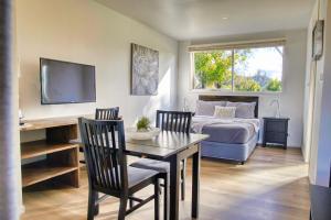 a living room with a bed and a table and chairs at Grapevines Boutique Accommodation in Pokolbin