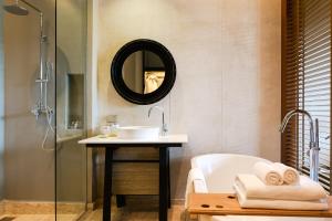 a bathroom with a sink, mirror and bath tub at Atta Lakeside Resort Suite - SHA Plus Certified in Mu Si