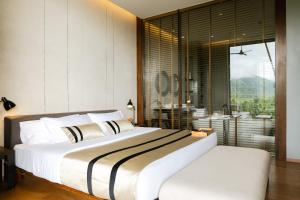a bedroom with a large bed and a large window at atta Lakeside Resort Suite - SHA Plus Certified in Mu Si +40 photos