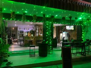 een restaurant met groene verlichting en tafels en stoelen bij Ban Por Fai in Cha Am