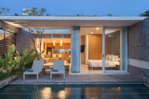 a villa with a bedroom and a pool at Hideaway Villas Bali Uluwatu by Kanaan Hospitality in Uluwatu