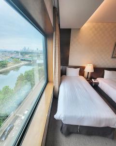 Habitación de hotel con 2 camas y ventana grande. en Niagara Hotel en Seúl
