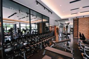 SC Park Hotel في بانكوك: صالة ألعاب رياضية مع صفوف من معدات التمرين في مبنى