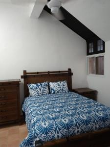 Schlafzimmer mit einem Bett mit einer blauen und weißen Bettdecke in der Unterkunft Sosua Apartment 4-Bedrooms in Sosúa